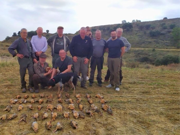 Groupe de chasseurs réunis autour du tableau de chasse de perdrix rouges